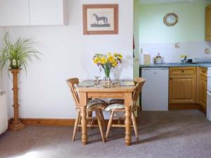 ピカリングにあるStable Cottageのキッチン(テーブル、椅子、花付)