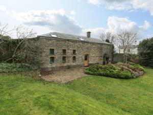 an old stone house with a garden in front of it at The Coach House in Abergavenny