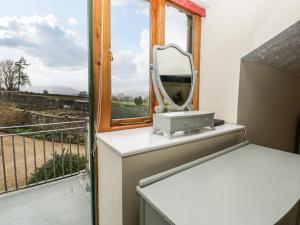 a mirror sitting on a counter next to a window at The Coach House in Abergavenny