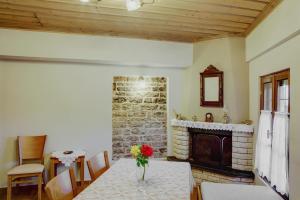 a dining room with a table and a fireplace at Archontiko Evridikis in Vitsa