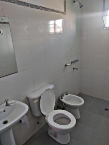 ein weißes Bad mit einem WC und einem Waschbecken in der Unterkunft La Candelaria in Humahuaca