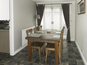 a dining room table and chairs in a room with a window at River Cottage in Staithes