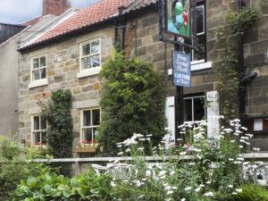 a street sign in front of a brick house at River Cottage in Staithes