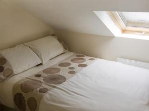 a bed in a small room with a window at The Loft in Annan