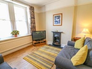 a living room with a couch and a television at Riverside View in Grange Over Sands