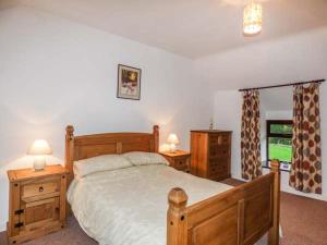 スランベドルにあるY Bwthynのベッドルーム1室(木製ベッド1台、ナイトスタンド2台、ランプ2つ付)