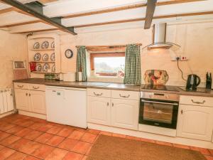 uma cozinha com armários brancos e uma janela em The Granary em Kirkby Lonsdale