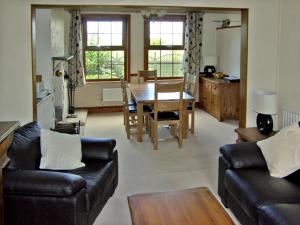 ein Wohnzimmer mit einem Tisch und ein Esszimmer in der Unterkunft Railway Cottage in Fairbourne + 4 Fotos