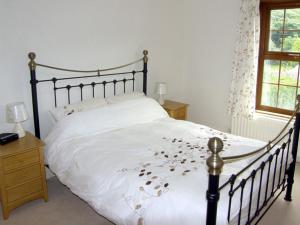 a bedroom with a large bed with flowers on it at Railway Cottage in Fairbourne