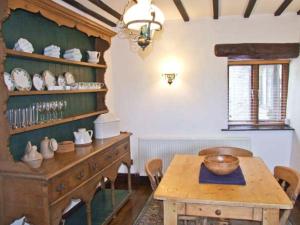 ein Esszimmer mit einem Holztisch und einem Holzregal in der Unterkunft The Cottage in Buxton + 1 Foto