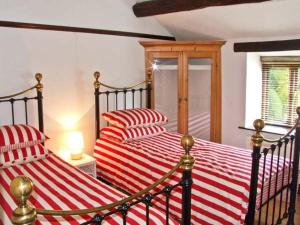 a bedroom with two beds with red and white striped sheets at The Cottage in Buxton