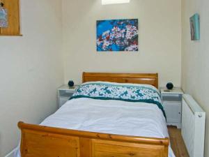 a bedroom with a wooden bed and two dressers at Stone Cottage in Mold