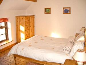um quarto com uma cama branca e uma janela em Tailor's Cottage em Abbey-Cwmhir