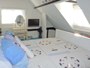 a bedroom with a bed and a television and windows at Little Thatch in Walton-on-the-Naze