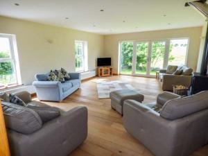 a large living room with couches and a television at Chapel House in Llantrisant