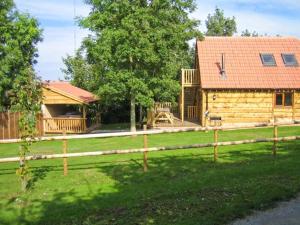 a wooden fence in front of a log cabin at Ash Lodge in Watchet