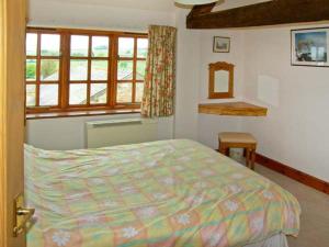a bedroom with a bed and a window at The Granary in Craven Arms