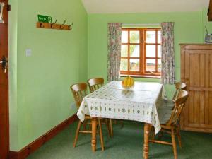 a dining room with a table with chairs and a window at The Granary in Craven Arms