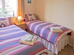 2 aparte bedden in een kamer met een raam bij Sunrise in Lowestoft