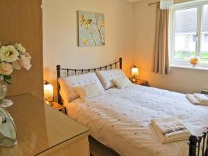 een slaapkamer met een bed, een bureau en een raam bij Sunrise in Lowestoft