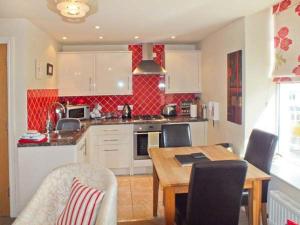 a kitchen with a table and a dining room at Swallows Nest in Coniston