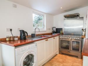 a kitchen with a washing machine and a sink at Newlands in Archiestown