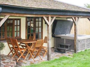 a patio with a grill and a table and chairs at Brambles Cottage in Great Malvern