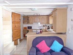 a kitchen with a purple couch with two colorful pillows at Seashell Cottage in Deal