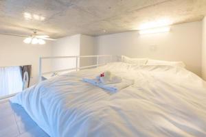 a white bed with a stuffed animal on top of it at ラフィット両国 in Tokyo