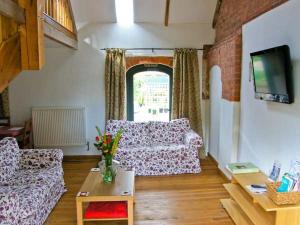 a living room with two couches and a window at Pear Tree Cottage in Ellesmere