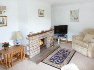 a living room with a fireplace and a couch at Mews Cottage in Penrith