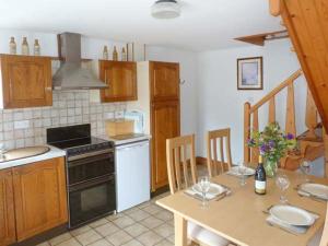 a kitchen with a table and a stove top oven at Mews Cottage in Penrith