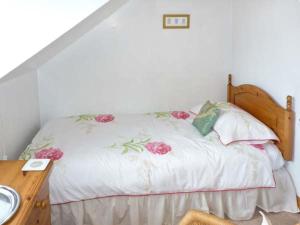 ペンリスにあるMews Cottageのベッドルーム1室(花の飾られたベッド1台付)