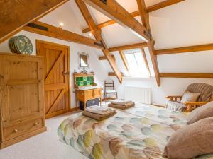 a bedroom with a large bed in a room with wooden ceilings at The Bothy in Lowick