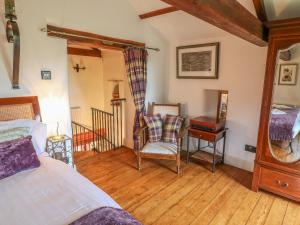 a bedroom with a bed and a table and a chair at The Bothy in Leyburn