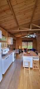 a large kitchen with white appliances and a wooden ceiling at EcoChalet Luxury in Ráquira