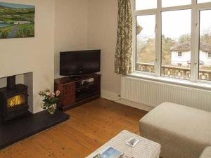 ein Wohnzimmer mit einem Kamin und einem TV in der Unterkunft Sunnyside in Great Malvern