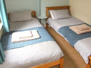 2 Betten mit Handtüchern auf einem Zimmer in der Unterkunft Sunnyside in Great Malvern