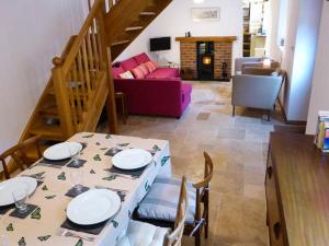 a dining room with a table and a living room at The Old Stable in Weston-super-Mare