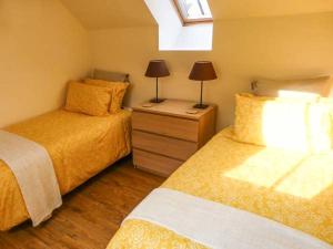 een kleine slaapkamer met 2 bedden en een raam bij The Old Stable in Weston-super-Mare