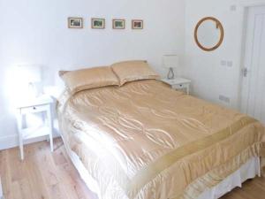 een bed in een slaapkamer met 2 tafels en een spiegel bij The Gatehouse in Leyburn