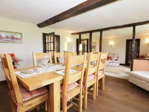 a dining room with a wooden table and chairs at Grange Farmhouse in Hainford