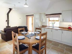 a kitchen and dining room with a table and chairs at Beudy in Llangwm