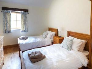 sypialnia z 2 łóżkami i oknem w obiekcie Beudy w mieście Llangwm