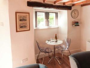 een kamer met een tafel en stoelen en een klok bij The Round House in Leyburn