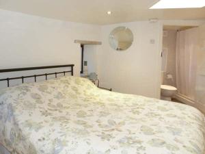 a bedroom with a bed and a bathroom at The Round House in Leyburn