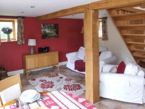 a living room with white furniture and red walls at Mallard in Newnham