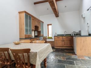 La cocina está equipada con mesa, sillas, mesa y encimera. en Longside, en Abergavenny