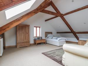 a attic bedroom with a bed and a table at Longside in Abergavenny