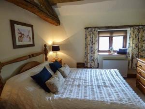 a bedroom with a large bed and a window at The Byre in Grange Over Sands